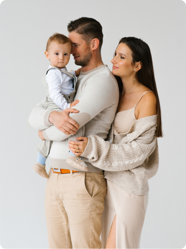 padre y madre agarrando a su hijo en brazos